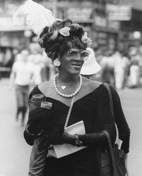 Marsha P. Johnson in 1977, wearing flowers in her hair, photographed in New York