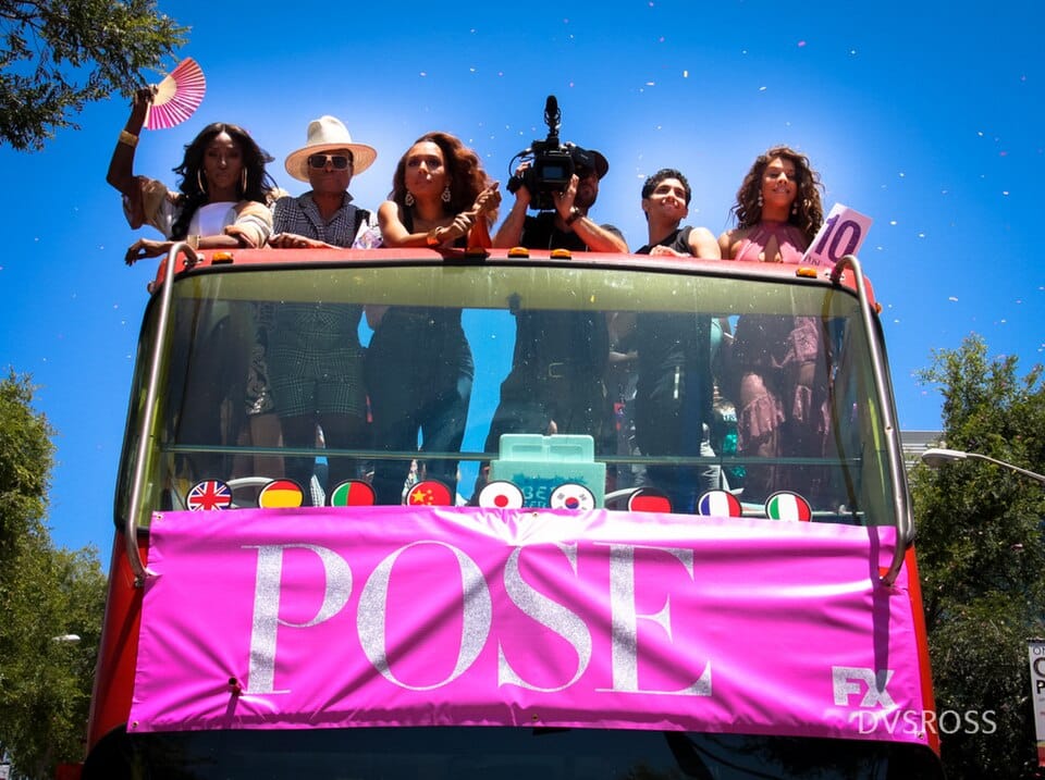 Five cast members of Pose FX including Billy Porter and Indya Moore  on a hot pink parade float at LA Pride 2018, confetti falling  against a bright blue sky